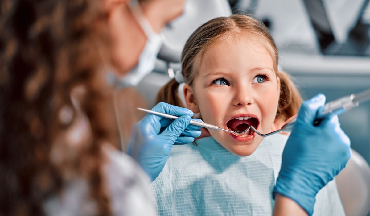 Laps istub hambaravi toolis ja naeratab